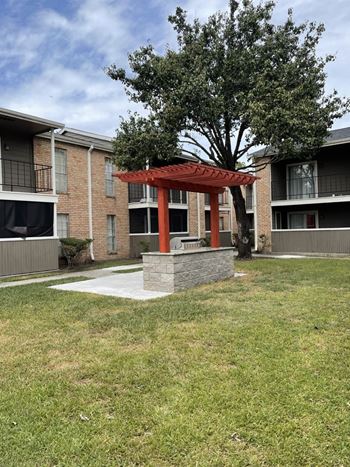 Outdoor pergola with grilling station and landscaped grounds